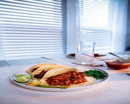 A home-cooked Mexican family meal layout featuring warm corn tortillas and traditional side dishes
